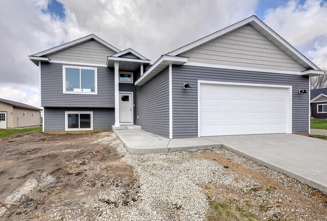tri-level home with a garage and concrete driveway