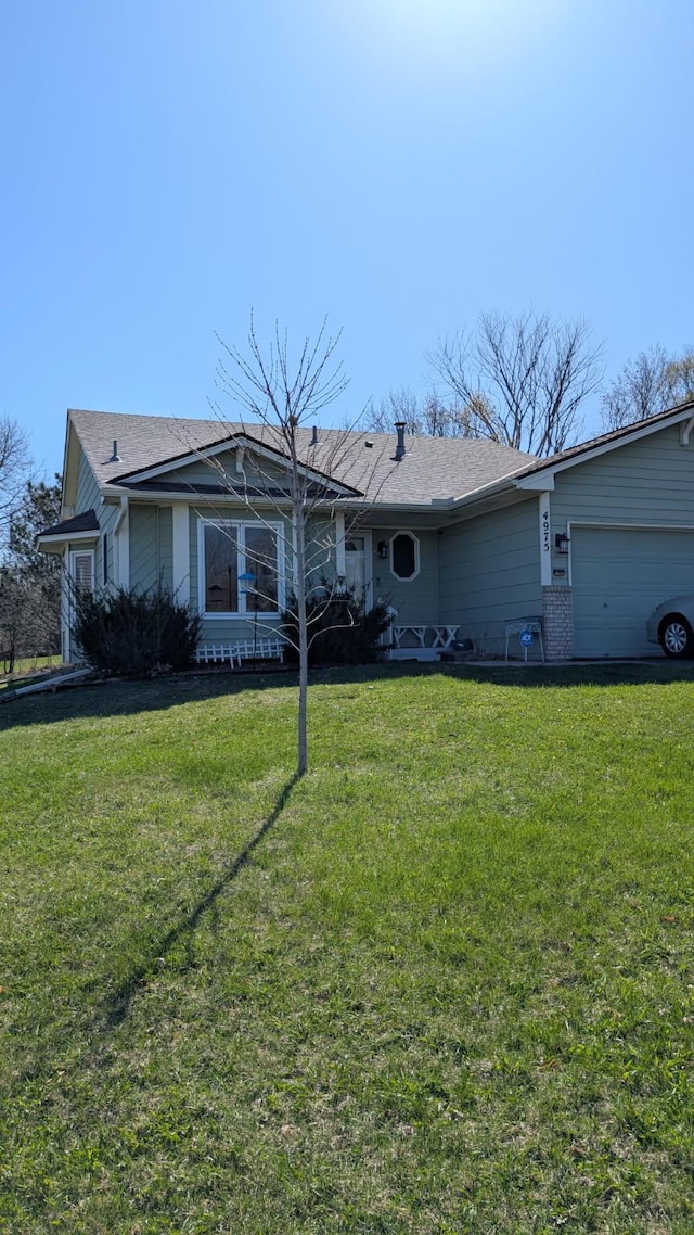 ranch-style house with a front lawn, a shingled roof, and an attached garage