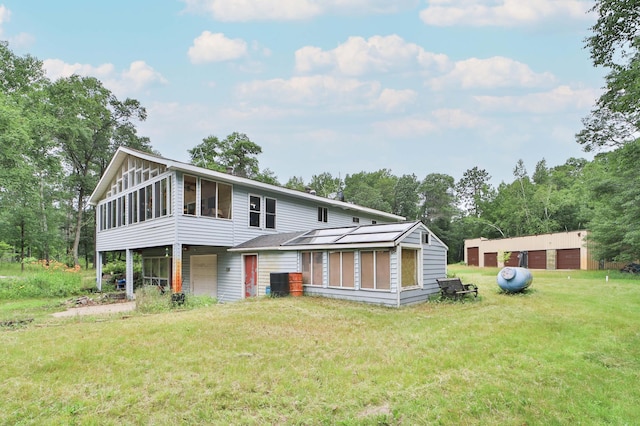 21682 Rebel Rd, Center Twp, MN 56465 - rear view of house featuring a sunroom, a lawn, and a garage