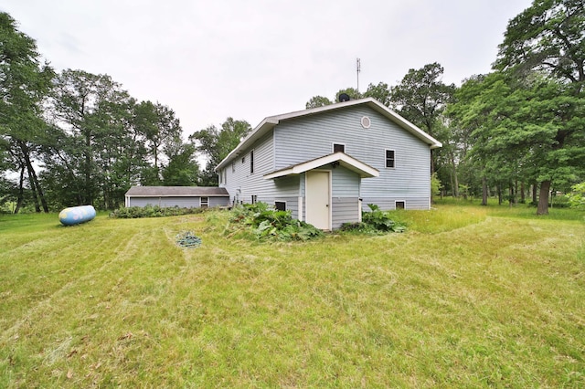 21682 Rebel Rd, Center Twp, MN 56465 - back of property featuring a lawn and view of wooded area