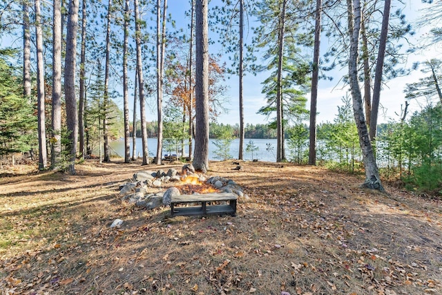 view of yard featuring a fire pit and a water view
