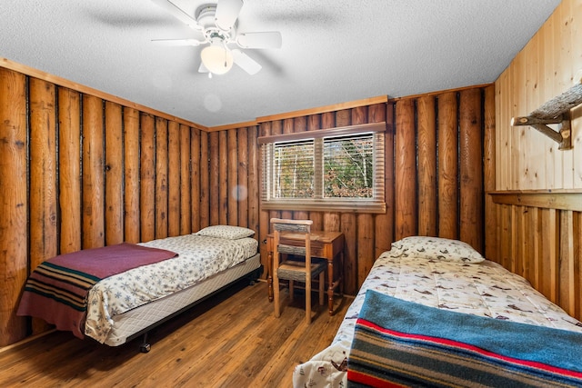 bedroom with a textured ceiling, a ceiling fan, and wood finished floors