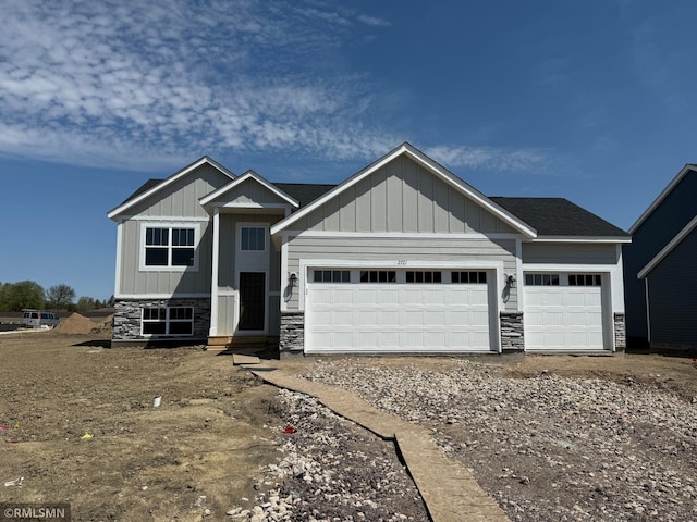 craftsman inspired home with stone siding, a garage, board and batten siding, and gravel driveway