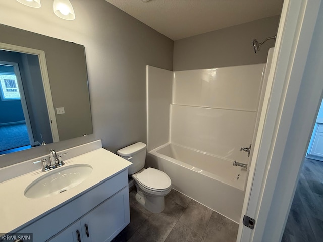 bathroom featuring toilet, vanity, and tub / shower combination