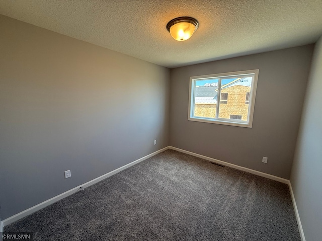 carpeted empty room featuring baseboards and a textured ceiling