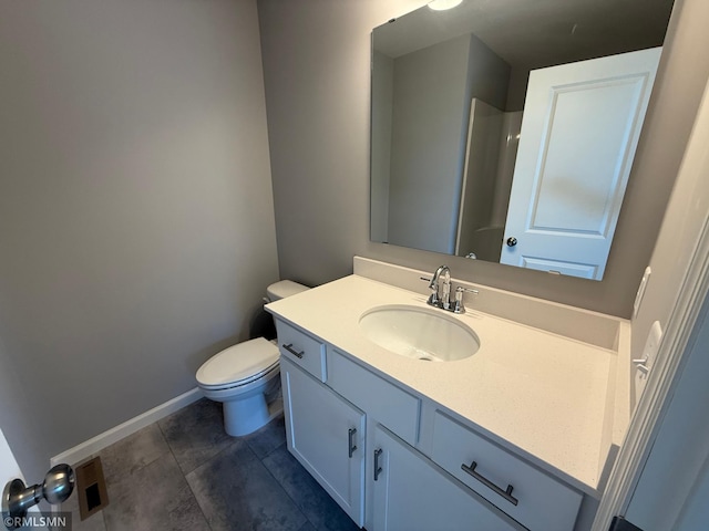 bathroom featuring baseboards, vanity, and toilet
