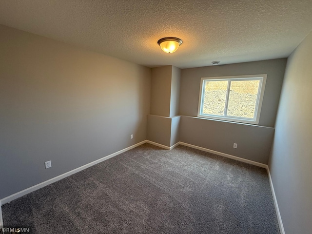 empty room featuring carpet flooring, baseboards, and a textured ceiling