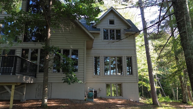rear view of property with roof with shingles