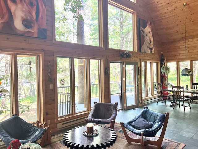 sunroom / solarium featuring wood walls, high vaulted ceiling, and wooden ceiling