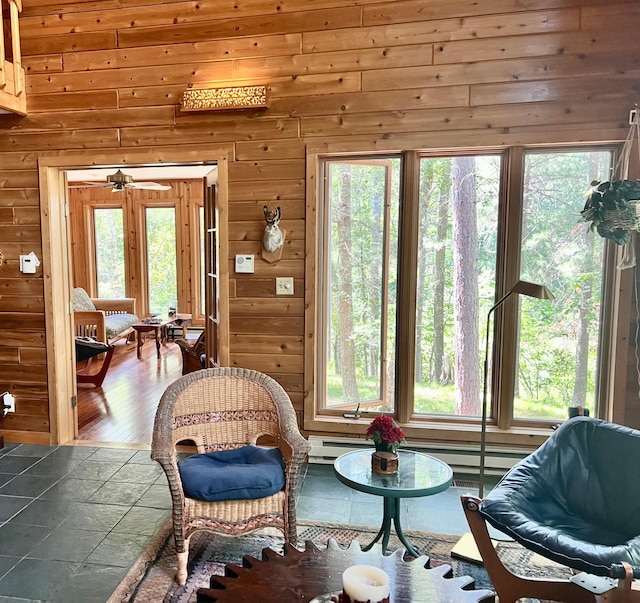 living area featuring wood walls, wood finished floors, and a healthy amount of sunlight