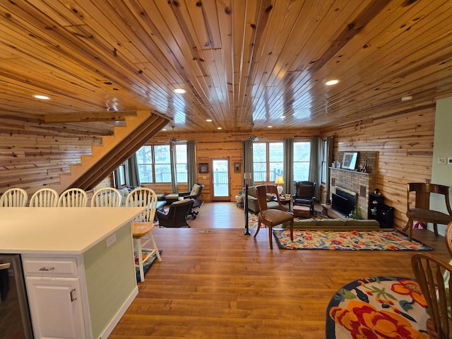 living area featuring wooden walls, recessed lighting, wood finished floors, and a fireplace