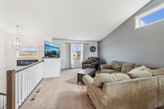 carpeted living area featuring a chandelier, a wealth of natural light, and visible vents