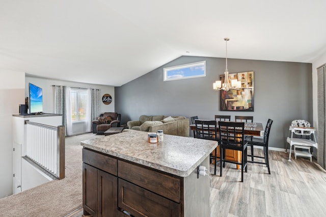 kitchen featuring vaulted ceiling, dark brown cabinets, light wood-type flooring, light countertops, and a notable chandelier