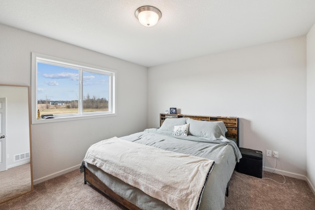 carpeted bedroom featuring baseboards and visible vents