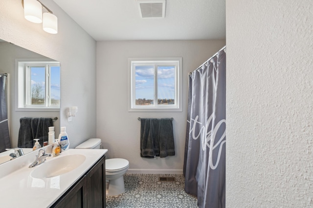 bathroom with visible vents, toilet, a wealth of natural light, and vanity