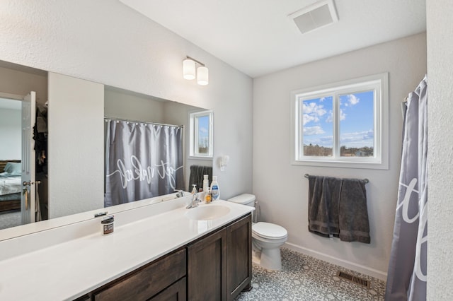 ensuite bathroom with toilet, vanity, tile patterned floors, and visible vents