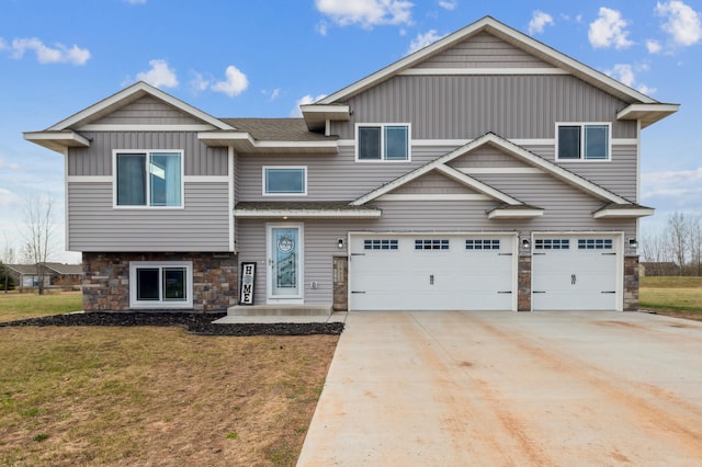 view of front of home featuring stone siding, driveway, a front yard, and a garage