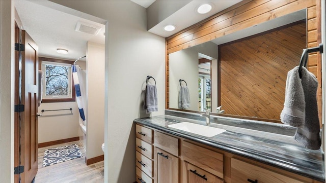 12468 Hermosa Beach Rd NW, Alexandria, MN 56308 - bathroom featuring vanity, toilet, shower / bath combination with curtain, wood walls, and wood finished floors