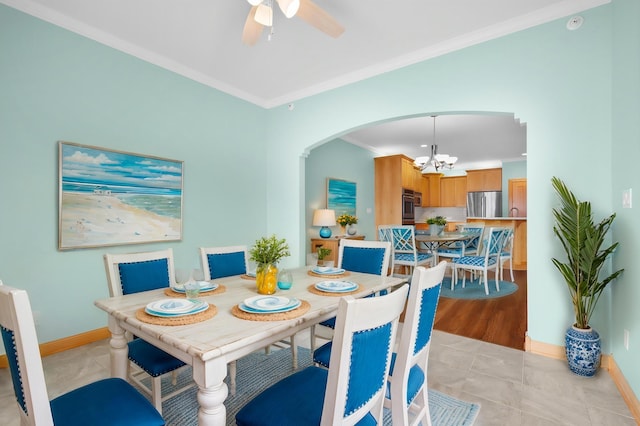 200 Michigan St Unit 1, Lake City, MN 55041 - dining room with arched walkways, light tile patterned flooring, crown molding, baseboards, and ceiling fan with notable chandelier