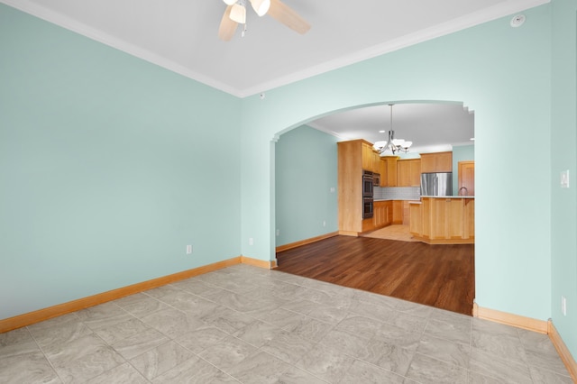 200 Michigan St Unit 1, Lake City, MN 55041 - unfurnished living room featuring arched walkways, crown molding, baseboards, and ceiling fan with notable chandelier