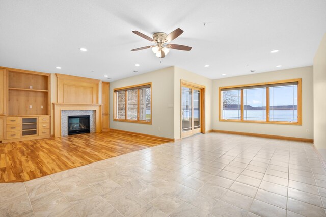 200 Michigan St Unit 1, Lake City, MN 55041 - unfurnished living room featuring ceiling fan, baseboards, a glass covered fireplace, and recessed lighting