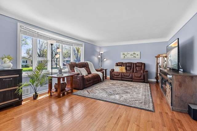 living area featuring light wood-type flooring and baseboards