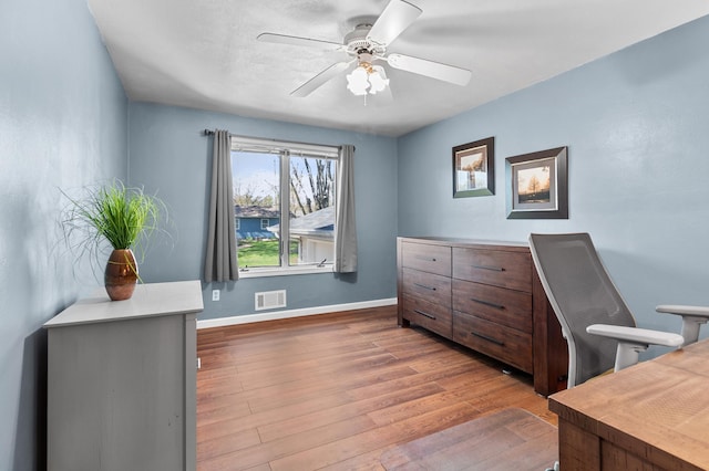 office space with wood finished floors, a ceiling fan, and baseboards