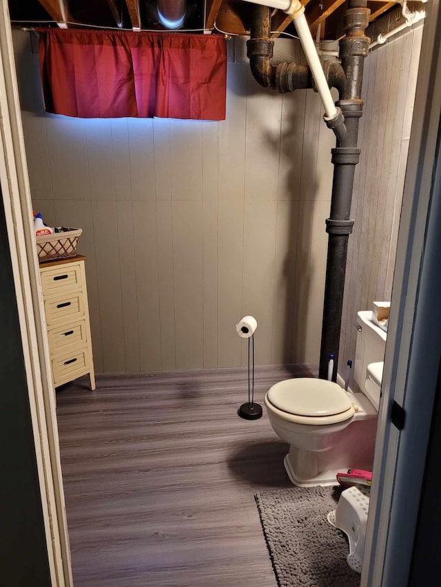 106 Mcphail Ave N, Caledonia, MN 55921 - bathroom featuring wood finished floors, toilet, and wooden walls