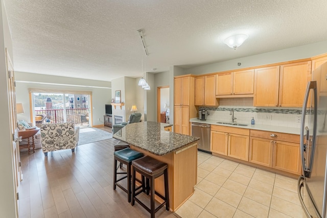 630 Main St N Unit 308, Stillwater, MN 55082 - kitchen with appliances with stainless steel finishes, a sink, a breakfast bar area, a textured ceiling, and open floor plan