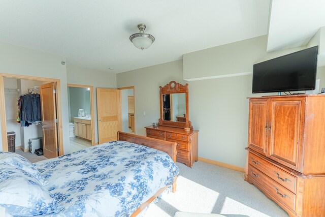 630 Main St N Unit 308, Stillwater, MN 55082 - bedroom featuring a spacious closet, baseboards, ensuite bath, and light colored carpet