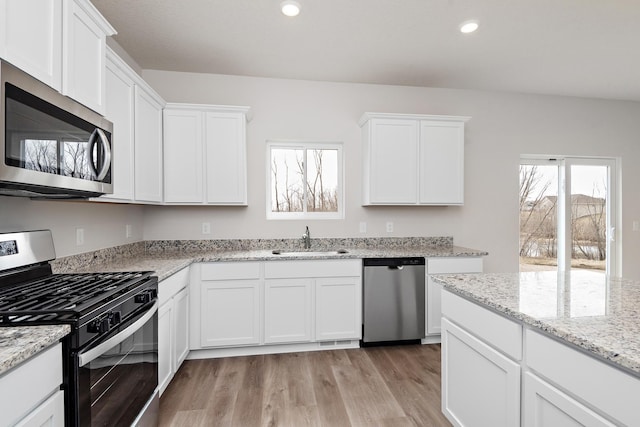 10080 Twin Lakes Pkwy NW, Elk River, MN 55330 - kitchen featuring stainless steel appliances, light wood-style flooring, healthy amount of natural light, white cabinets, and recessed lighting