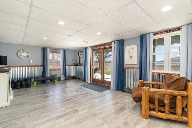 living area featuring light wood-style floors and a drop ceiling