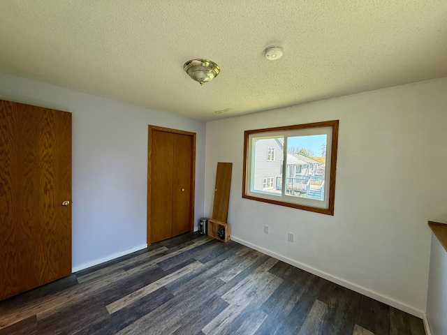14303 Utica Ave, Savage, MN 55378 - unfurnished bedroom featuring dark wood finished floors, baseboards, a closet, and a textured ceiling
