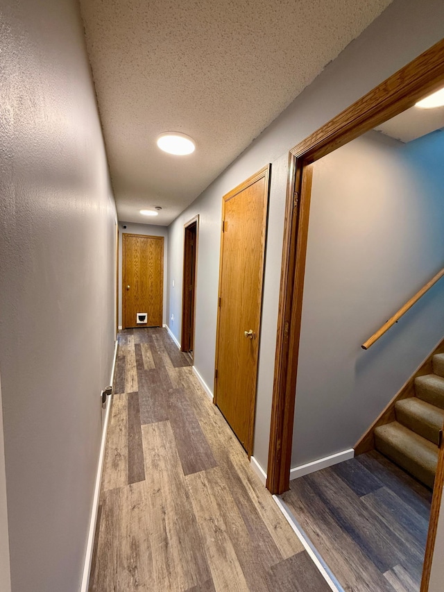 14303 Utica Ave, Savage, MN 55378 - hall with wood finished floors, stairway, baseboards, and a textured ceiling