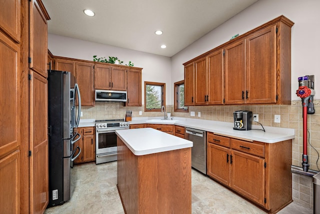kitchen with tasteful backsplash, a kitchen island, light countertops, a sink, and stainless steel appliances