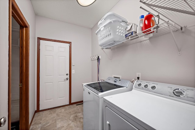 laundry area with baseboards, laundry area, and washing machine and clothes dryer