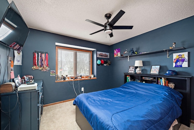 bedroom featuring a textured ceiling, baseboards, a ceiling fan, and carpet floors