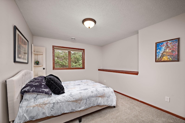 carpeted bedroom featuring baseboards and a textured ceiling