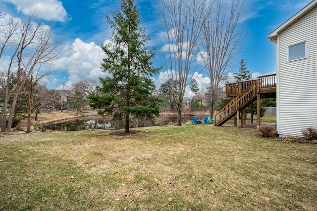 view of yard featuring a deck with water view and stairway