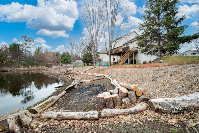 view of yard with stairway and a deck with water view