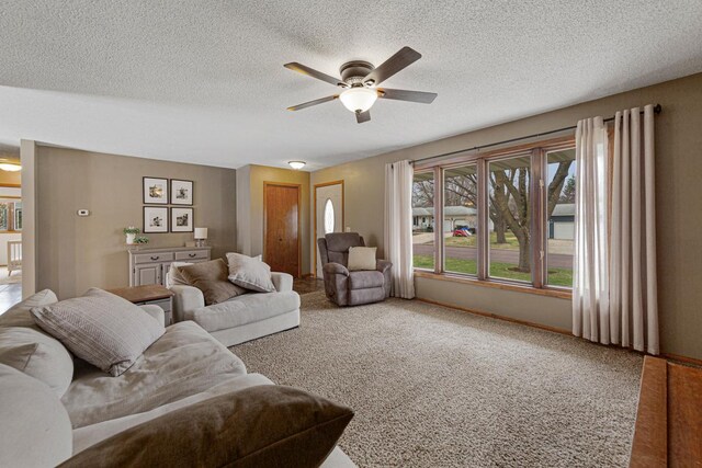 living room featuring a ceiling fan, carpet flooring, and a textured ceiling