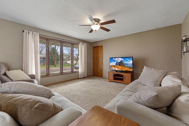 living room with ceiling fan, carpet floors, a textured ceiling, and baseboards
