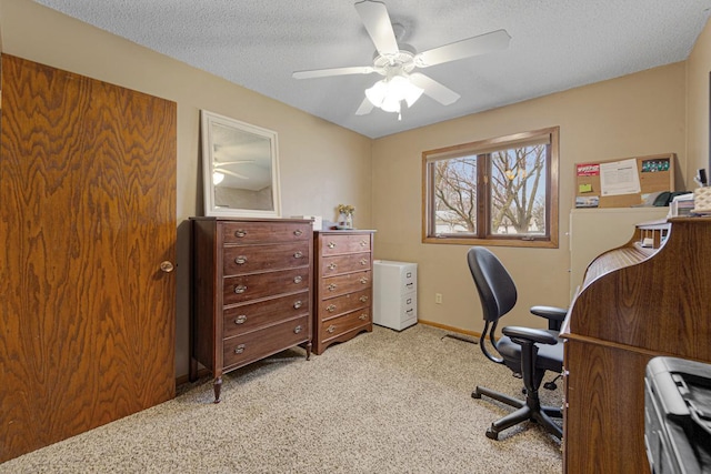 carpeted office with a textured ceiling, a ceiling fan, and baseboards