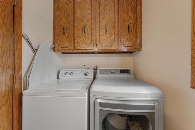 washroom featuring washing machine and clothes dryer and cabinet space