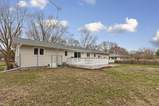 back of house featuring fence, central AC, a lawn, roof with shingles, and a deck