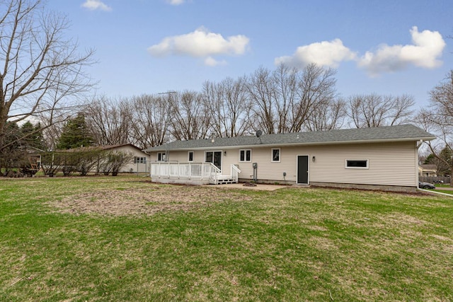 rear view of property featuring a lawn and a wooden deck
