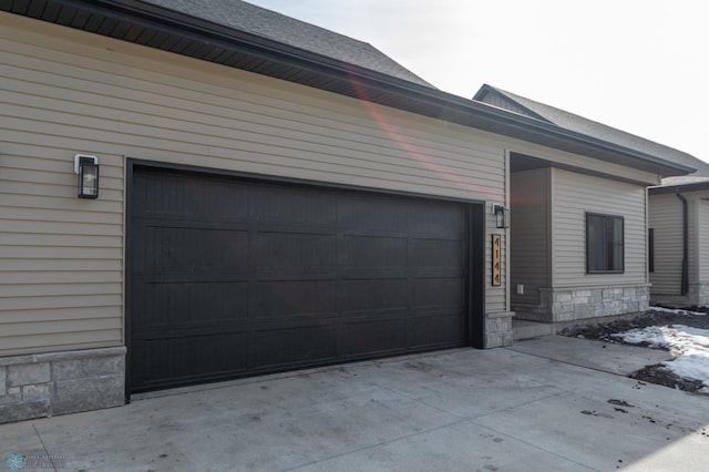 view of side of property with stone siding and concrete driveway