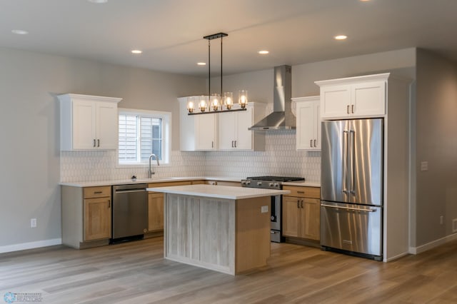 kitchen featuring light countertops, backsplash, wall chimney exhaust hood, stainless steel appliances, and a sink