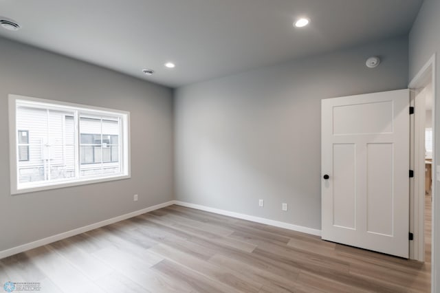 unfurnished room with light wood-style flooring, baseboards, and recessed lighting