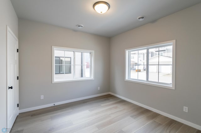 empty room featuring light wood-style flooring and baseboards